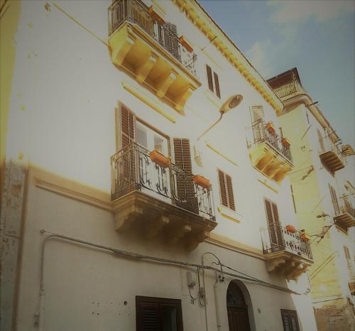 duży biały budynek z balkonami i oknami w obiekcie BED&BOOK Palazzo Cutelli w mieście Palermo