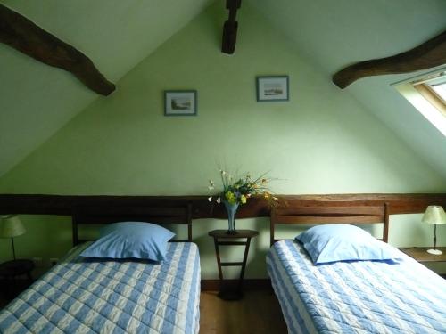 Monts的住宿－La grange de Candé，一间卧室设有两张床和花瓶