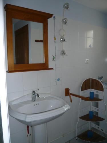 y baño con lavabo blanco y espejo. en La grange de Candé en Monts