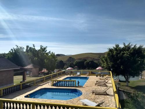 a resort with two pools and lounge chairs at Pousada & Pesca Esportiva Fazolin in Socorro