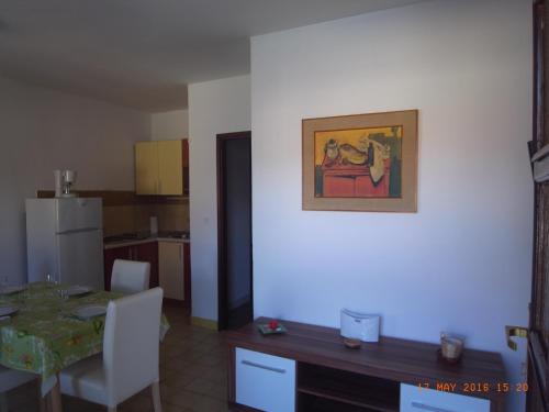 una cocina con una mesa y una pintura en la pared en Apartmani MW , Zuti apartman, en Baška