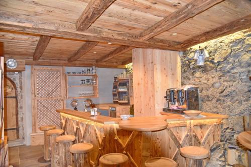 a kitchen with a wooden counter and stools in a room at Residence Blumenthalerhof in Lagundo