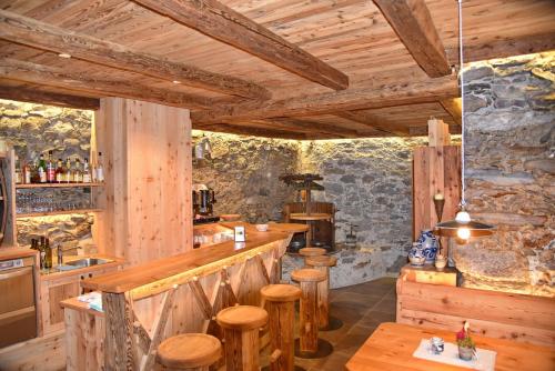 a bar in a restaurant with wooden walls and wooden stools at Residence Blumenthalerhof in Lagundo