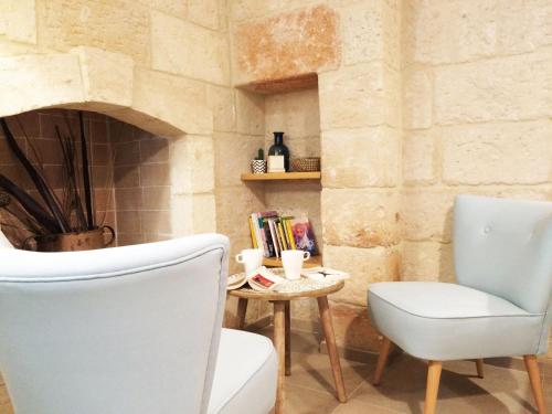 a room with a chair and a table and a fireplace at Suite Fasano in Fasano