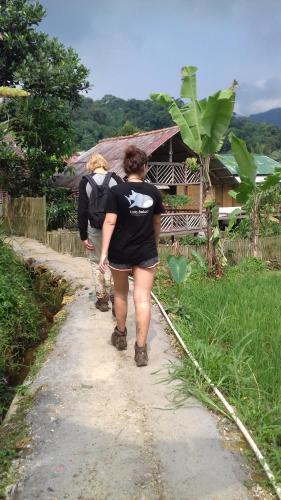 a couple of people walking down a dirt road at De Salak Homestay in Bogor