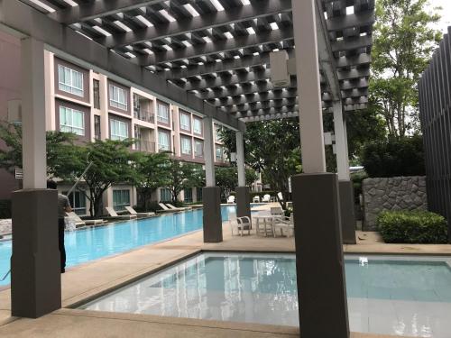 a swimming pool at a hotel with a building at Baan Peang Ploen Hua Hin 6/546 in Hua Hin