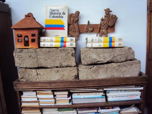 a book shelf with books and a bird house at Hotel Hacienda El Aserrio in Iza