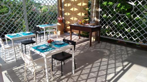 een patio met tafels en stoelen en een hek bij B&B Corallo in Capilungo