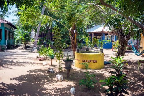 a yellow sign that reads retention in a garden at Arne's Place in Arugam Bay