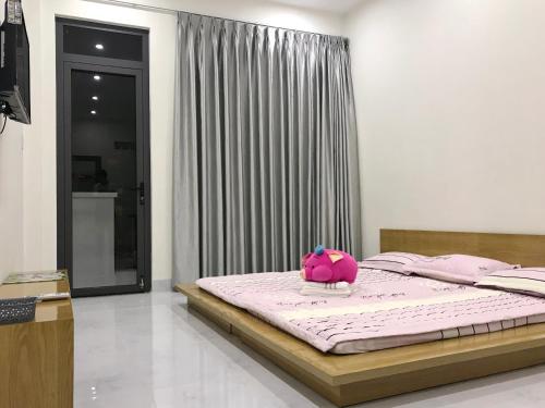 a pink stuffed animal sitting on a bed in a bedroom at 91 Homestay, Cafe, Bonsai in Vung Tau