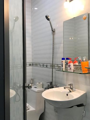 a white bathroom with a sink and a shower at 91 Homestay, Cafe, Bonsai in Vung Tau