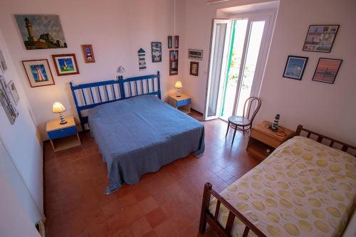 a bedroom with a blue bed and two chairs at Residenza Le Sprizze in Bagno