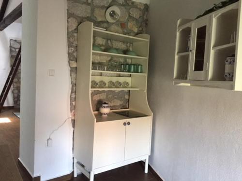 a white cabinet in a room with a wall at Old Town Apartment in Krk