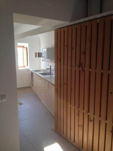 a kitchen with wooden sliding doors in a room at CASA NA VILA HISTÓRICA DE MOURÃO in Mourão