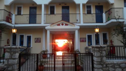 a large white building with a red door at Castellania Hotel Apartments in Livadia