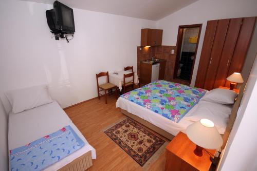 a small room with two beds and a television at Apartments Raičević in Budva