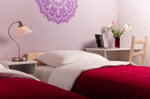 ヴロツワフにあるCilantro Bed & Breakfastのベッドルーム1室(ベッド2台、ランプ、花付)