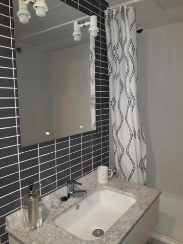 um lavatório de casa de banho com um espelho e uma cortina de chuveiro em Sant Jordi club de golf apart 4 x 2 em Sant Jordi