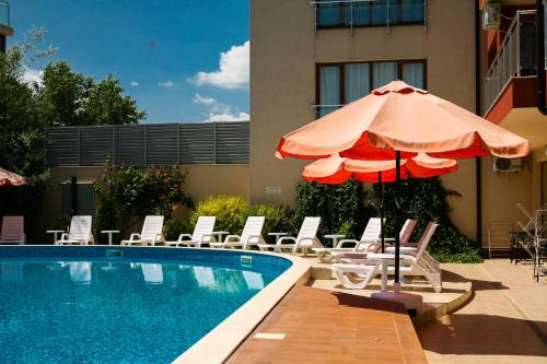 - une piscine avec des chaises et un parasol à côté de la piscine dans l'établissement Apart-Hotel Onegin & Thermal Zone, à Sozopol