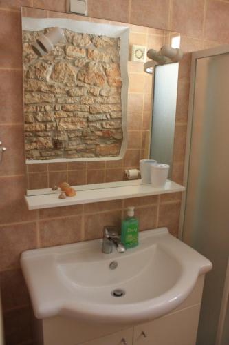 a bathroom with a sink and a stone wall at Villa Piazza grande in Fažana