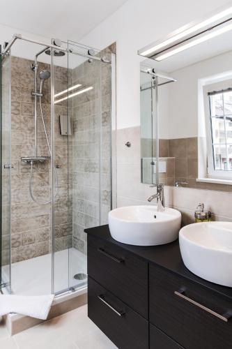a bathroom with two sinks and a shower at Strandhotel Sille in Reifnitz