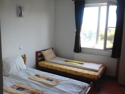 two twin beds in a room with a window at Guest House Familia in Samovodene