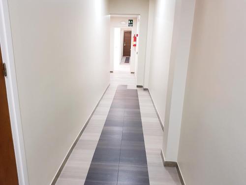 a long hallway with white walls and tile floors at Hotel Norai in Lloret de Mar
