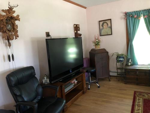 a living room with a large flat screen tv at Antique Rose Inn Windham in Windham