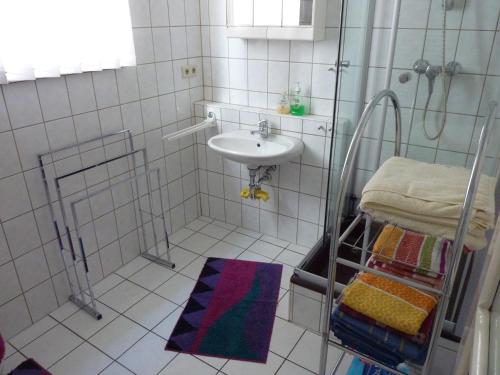 y baño con ducha, lavabo y lavamanos. en Schöne, gemütliche Wohnung, en Katzhütte