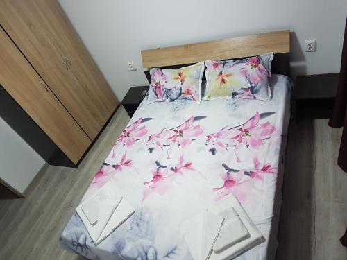 een slaapkamer met een bed met roze bloemen erop bij WaveSea Apartment in Eforie Nord