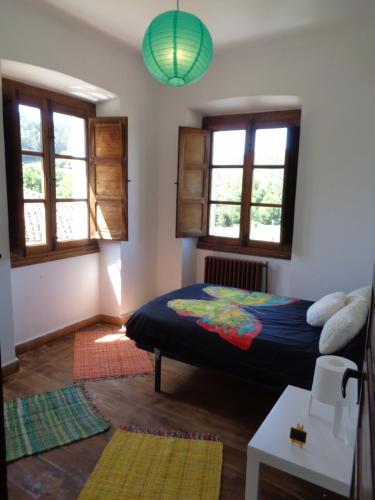 a bedroom with a bed and two windows at Casa Estrella in Pravia