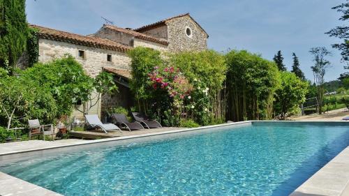 a swimming pool in front of a house at Mas Escombelle in Barjac