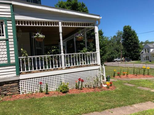 a house with a porch with flowers on it at Antique Rose Inn Windham in Windham