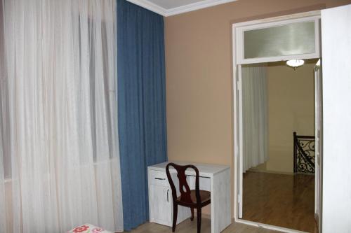 a room with a chair and a desk and a mirror at Villa Near The Batumi in Batumi