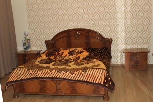 a wooden bed in a room with a wall at Villa Near The Batumi in Batumi