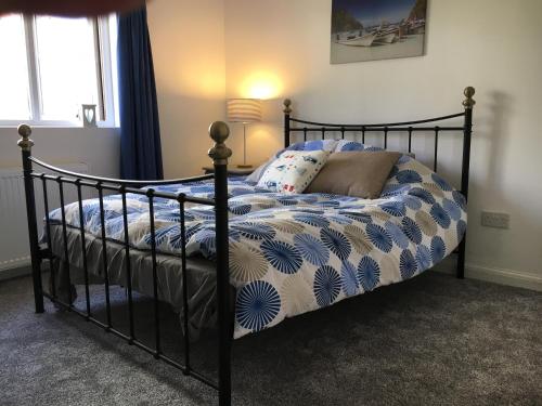 a bedroom with a bed with a blue and white comforter at Stunning, Newly Renovated, Townhouse in Central Dawlish in Dawlish