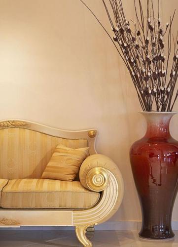 a vase sitting on the floor next to a couch with a vase at Grand Beach Hotel in Mýkonos City