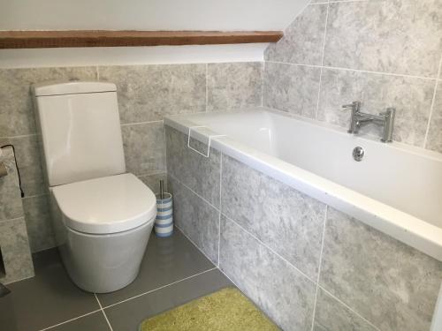 a bathroom with a toilet and a bath tub at Stunning, Newly Renovated, Townhouse in Central Dawlish in Dawlish