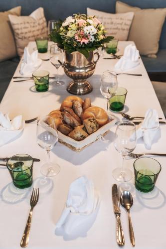 a table with a plate of bread and wine glasses at Strandhotel Sille in Reifnitz