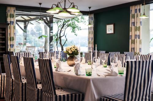 a dining room with a table with white tablecloths at Strandhotel Sille in Reifnitz