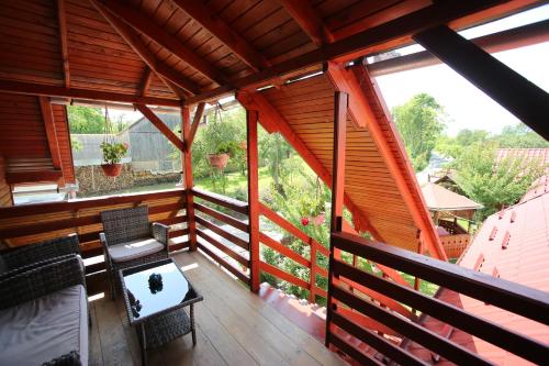 a room with a balcony with a table and chairs at Pensiune Saroklak in Sîncraiu