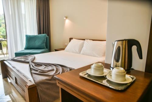 a hotel room with a bed with a tray with a tea kettle at Hotel Prova in Ulcinj