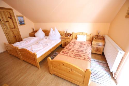 a bedroom with two beds and two night stands at Pensiune Saroklak in Sîncraiu