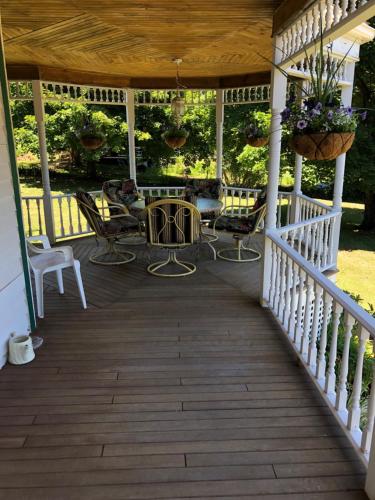 a porch with chairs and a table on a house at Antique Rose Inn Windham in Windham