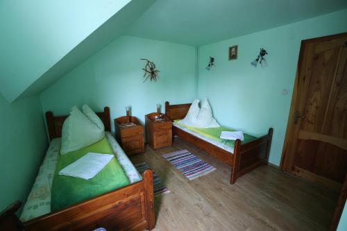 a room with two beds and a blue ceiling at Pensiune Saroklak in Sîncraiu
