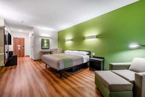 a bedroom with green walls and a bed and a couch at Motel 6-Mankato, MN in Mankato