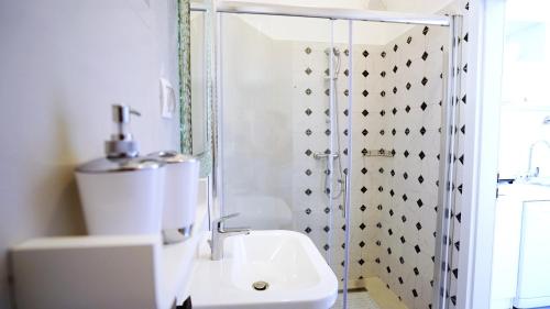 a white bathroom with a shower and a sink at Casa Gremar in Pješčana Uvala 