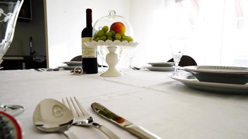 a table with a bottle of wine and a bowl of fruit at Casa Gremar in Pješčana Uvala 