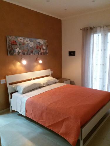 a bedroom with a bed with a red blanket at La dimora di Vituccio B&B in Avetrana