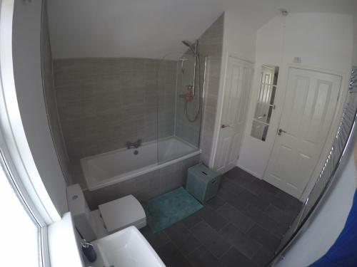 a bathroom with a shower and a toilet and a sink at Portstewart Holiday Home in Portstewart